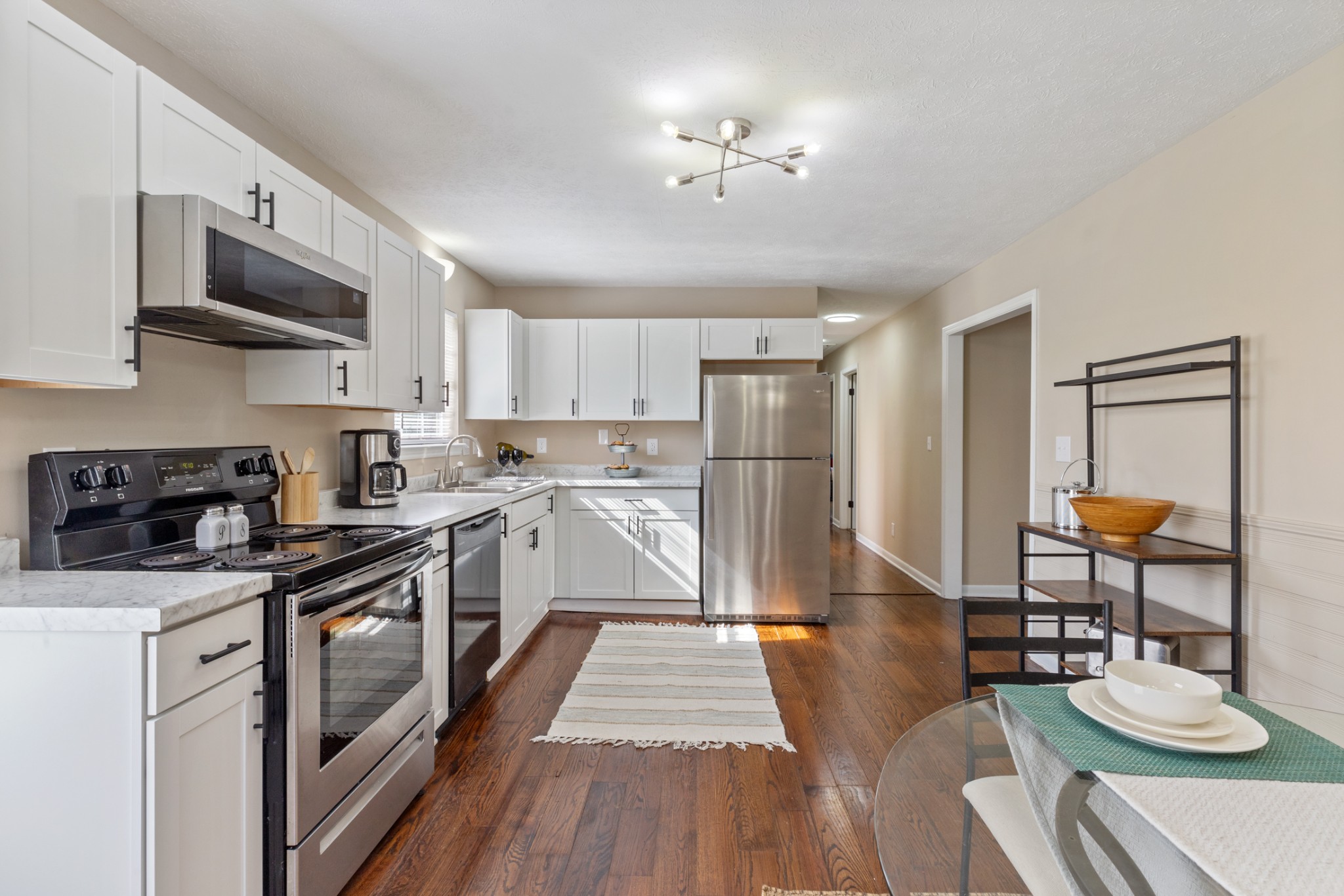108 Aaron Drive Burns, TN 37029 - Photo 12 of 31 a kitchen with stainless steel appliances granite countertop a refrigerator a stove a sink dishwasher and white cabinets with wooden floor