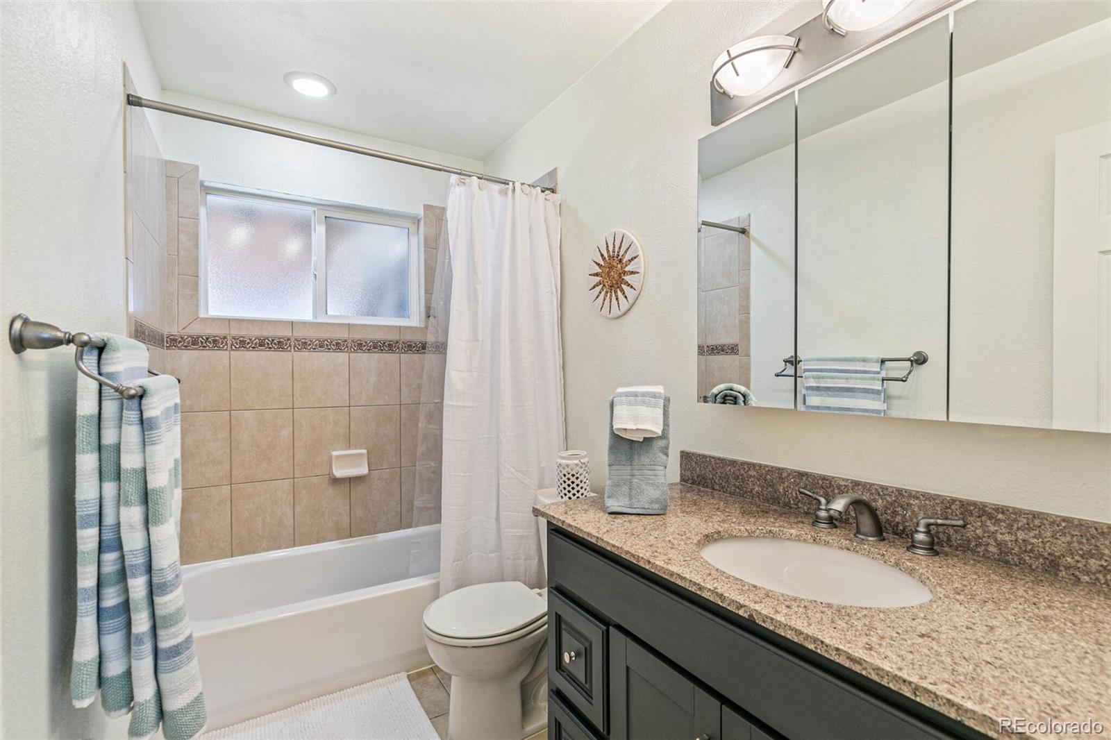 10800 Larry Drive Northglenn, CO 80233 - Photo 12 of 28 a bathroom with a granite countertop sink toilet and shower