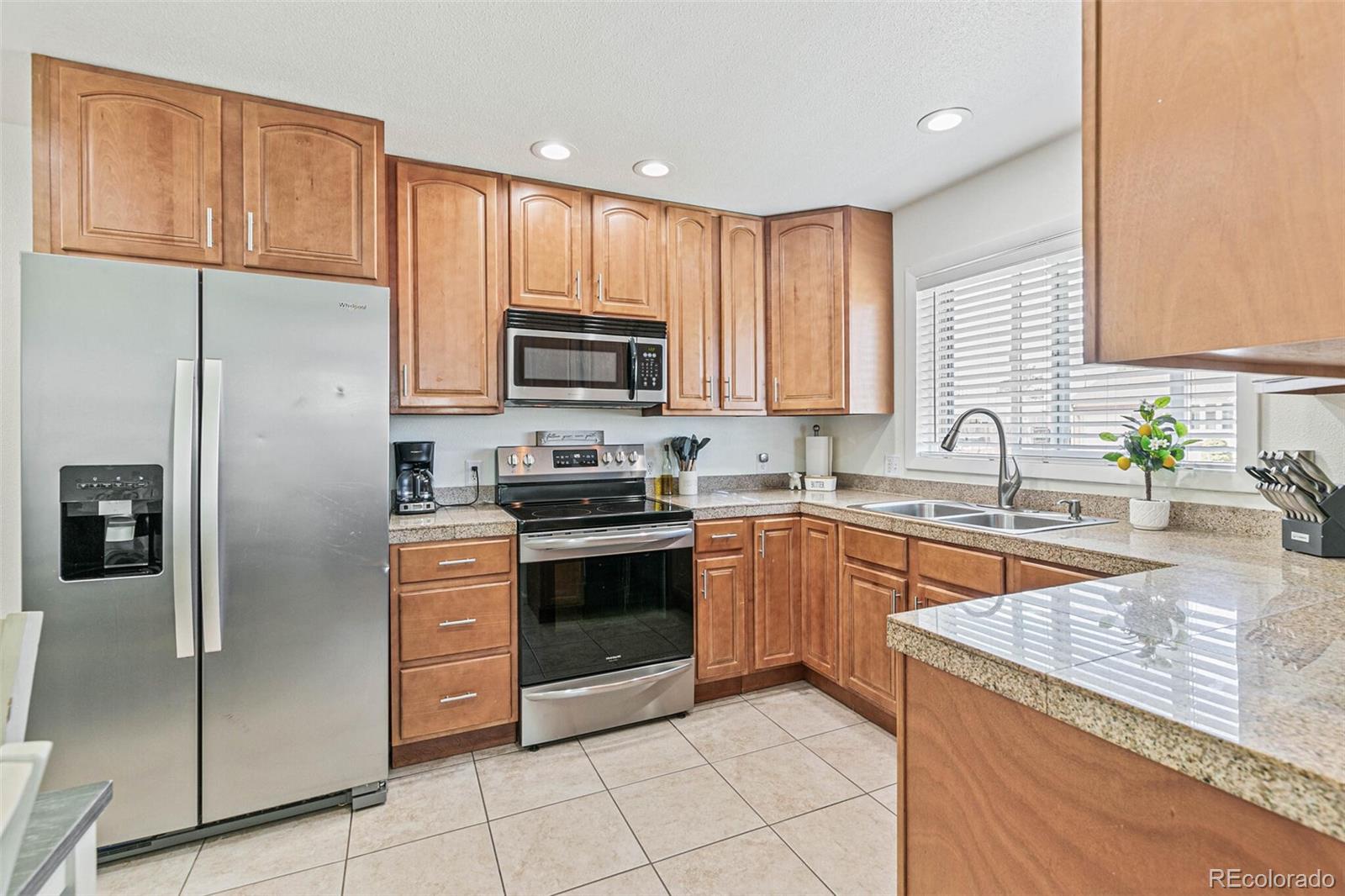 10800 Larry Drive Northglenn, CO 80233 - Photo 6 of 28 a kitchen with stainless steel appliances granite countertop a refrigerator stove and microwave