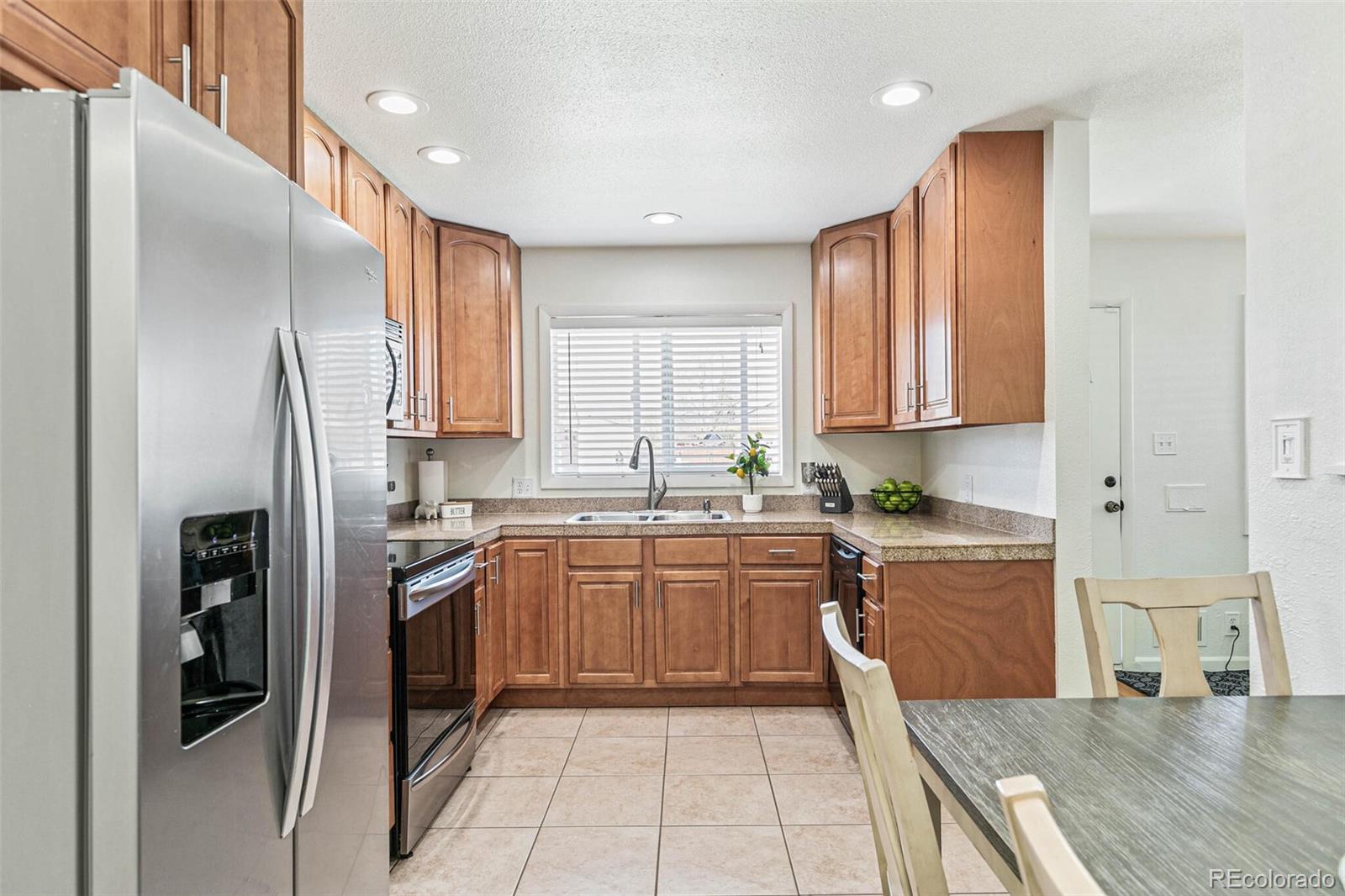 10800 Larry Drive Northglenn, CO 80233 - Photo 7 of 28 a kitchen with stainless steel appliances granite countertop a refrigerator sink and cabinets
