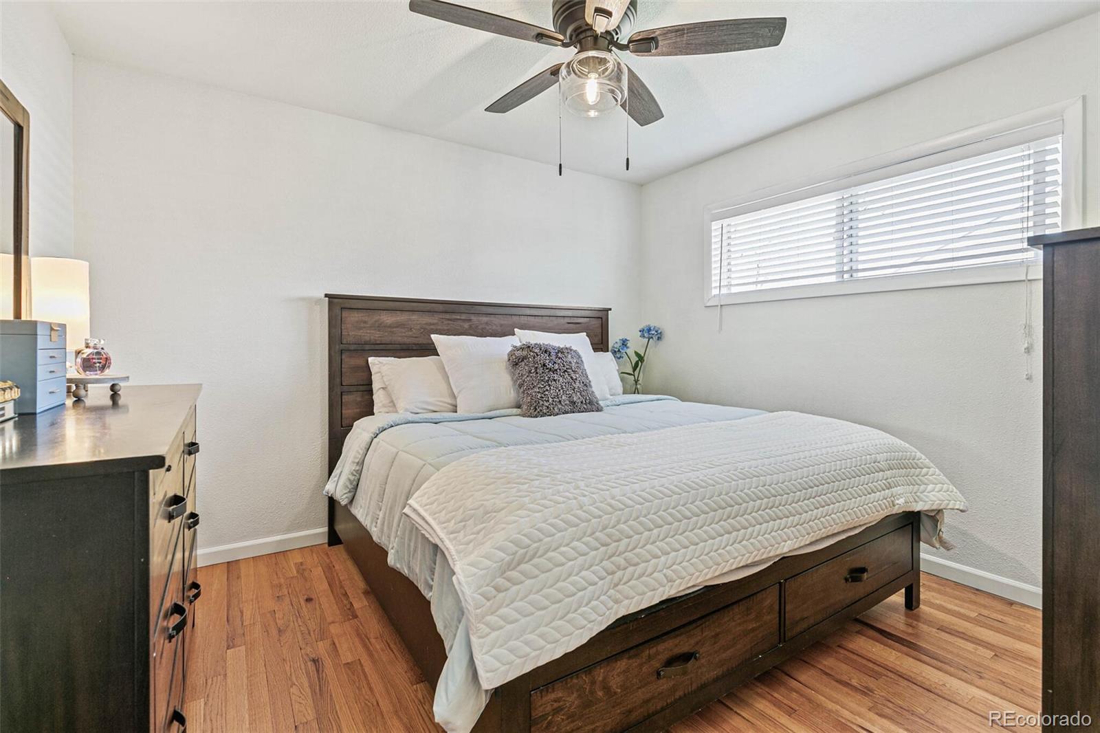 10800 Larry Drive Northglenn, CO 80233 - Photo 10 of 28 a bedroom with a bed and a chandelier