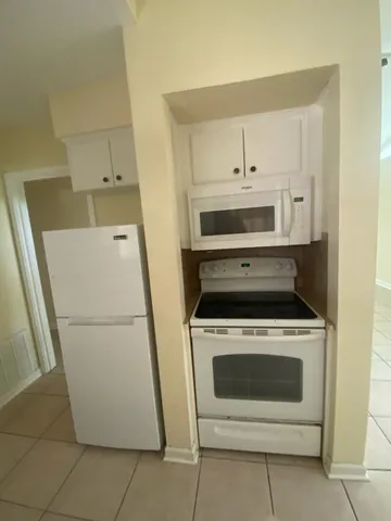 a white stove top oven sitting inside of a kitchen