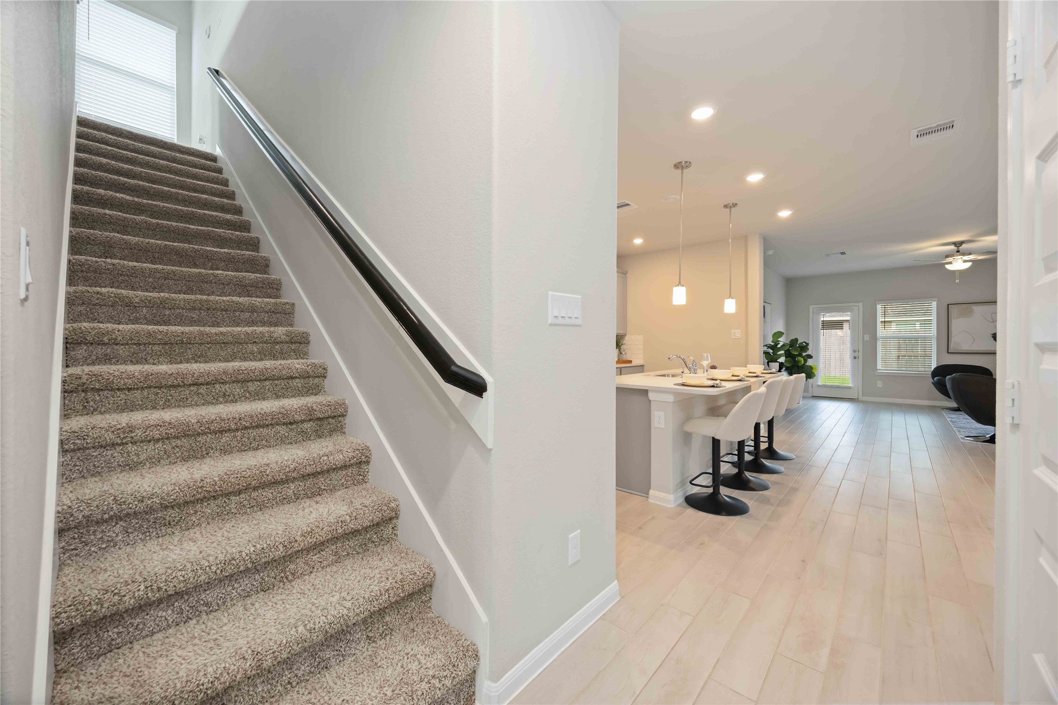 6814 Ventura Drive Rosharon, TX 77583 - Photo 19 of 30 Just off the entry, the carpeted staircase offers a comfortable rise to the upper floor, with a smooth wall-mounted handrail for added support. A window at the landing brings in natural light, creating a bright path upward.
