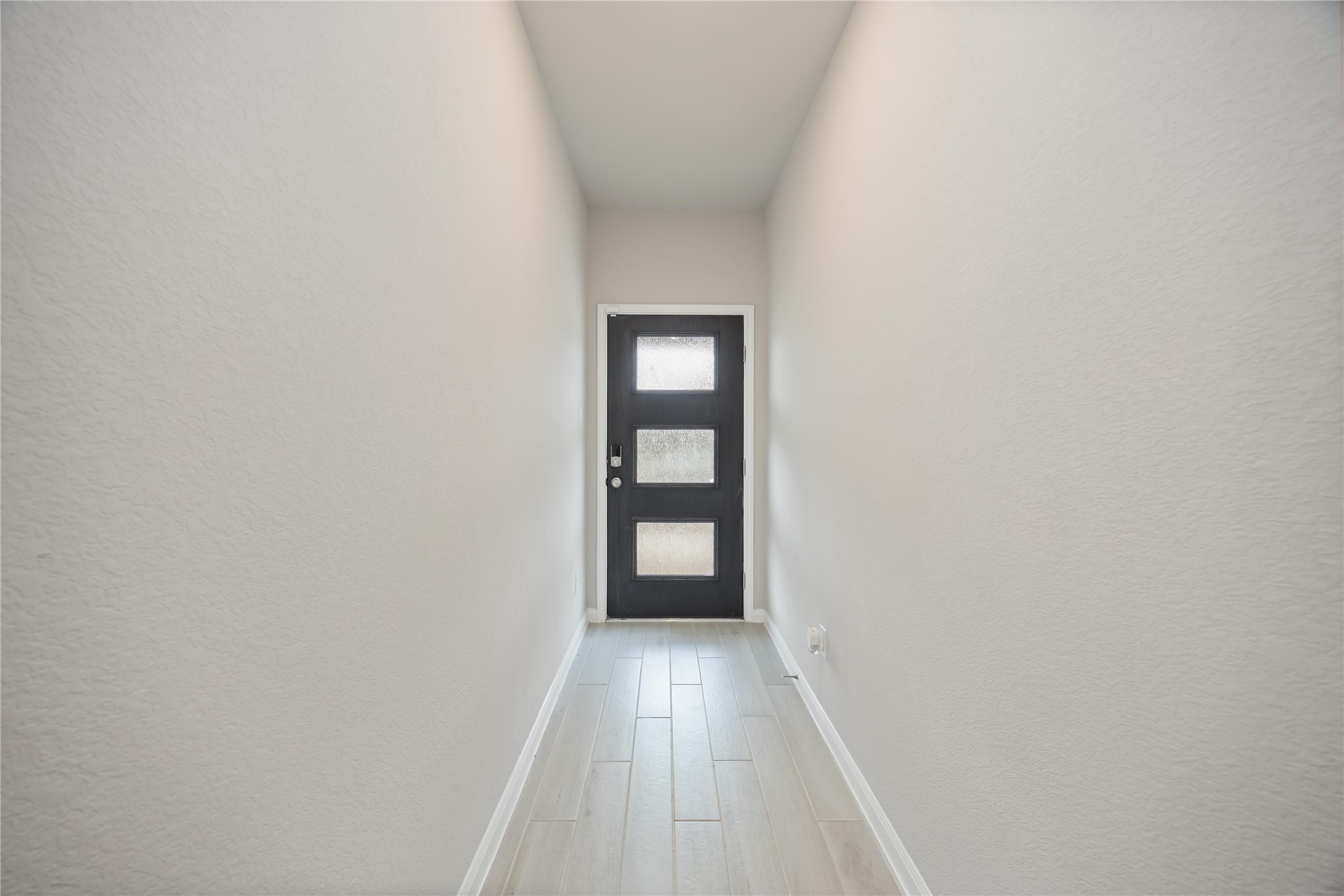 6814 Ventura Drive Rosharon, TX 77583 - Photo 27 of 30 Step inside to a bright entryway, where light pours through the glass-paneled front door, casting a soft glow on the hallway that draws you gently toward the heart of the home.
