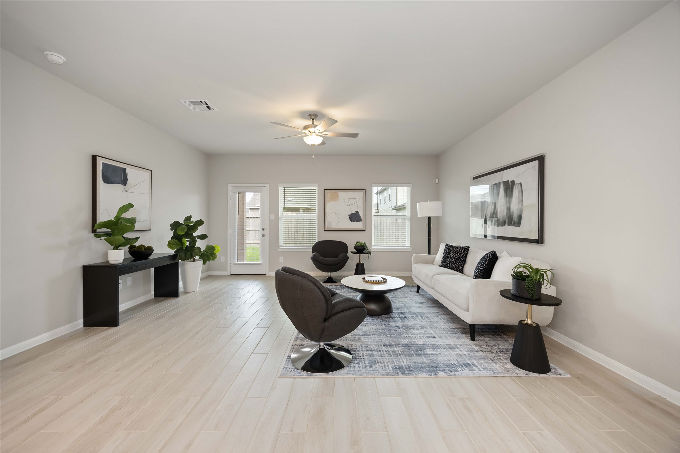 6814 Ventura Drive Rosharon, TX 77583 - Photo 3 of 30 Designed for both comfort and connection, the spacious living area offers room for generous seating, with tall windows and a glass-paneled door framing the view of the patio and the green yard beyond.