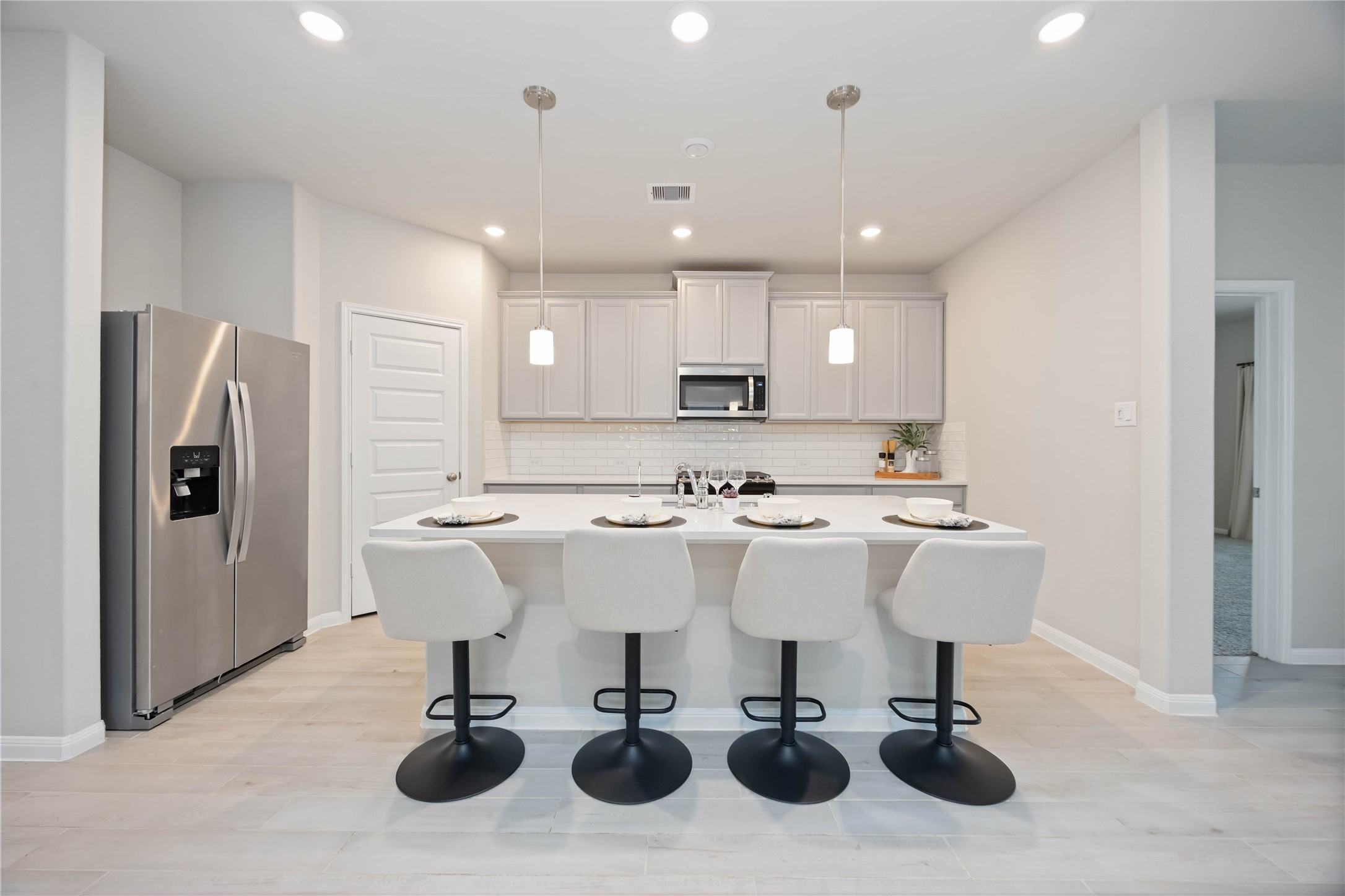 6814 Ventura Drive Rosharon, TX 77583 - Photo 5 of 30 Anchoring the kitchen is a large island with seating and sink, illuminated by pendant lights. Generous cabinetry, ample countertop space, and recessed lighting provide the perfect canvas for culinary creativity.