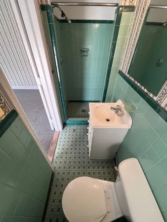 a bathroom with a toilet sink and mirror