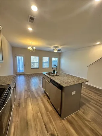 a kitchen with granite countertop a stove and a wooden floors