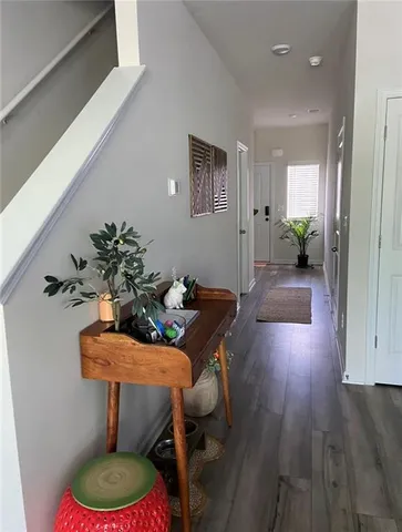 a dining room with furniture a potted plant and wooden floor