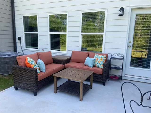 a outdoor living room with furniture and a large window