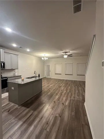 a large room with lots of counter space and wooden floor