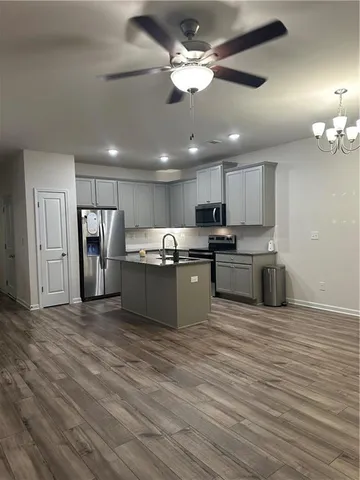 a large kitchen with stainless steel appliances granite countertop a stove and a refrigerator
