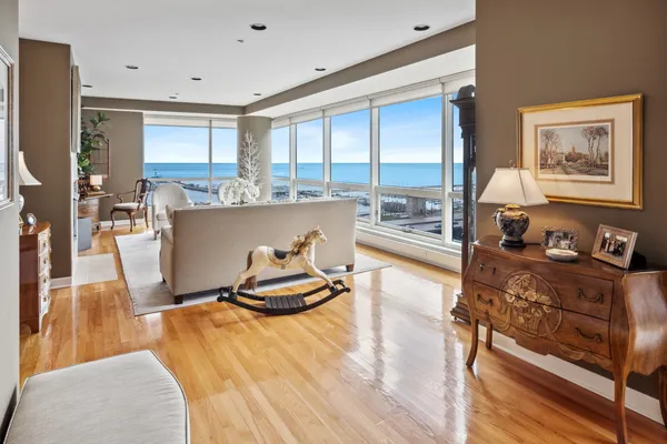 a living room with furniture a flat screen tv and a floor to ceiling window