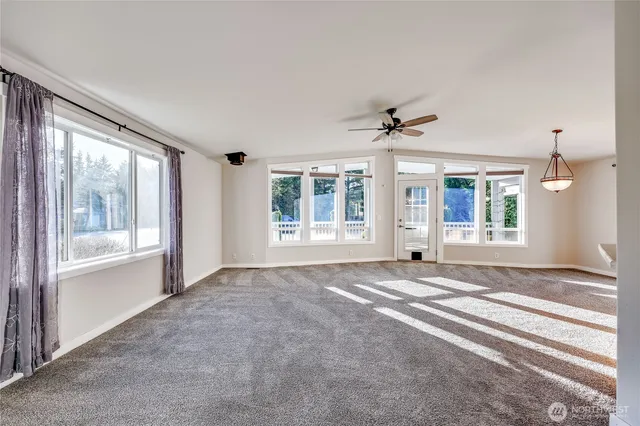a view of an empty room with a window and a ceiling fan