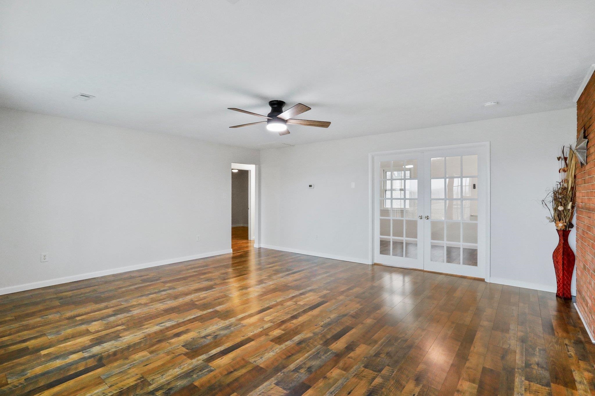 18196 New Market Road Timberville, VA 22853 - Photo 3 of 34 a view of an empty room with a window and wooden floor
