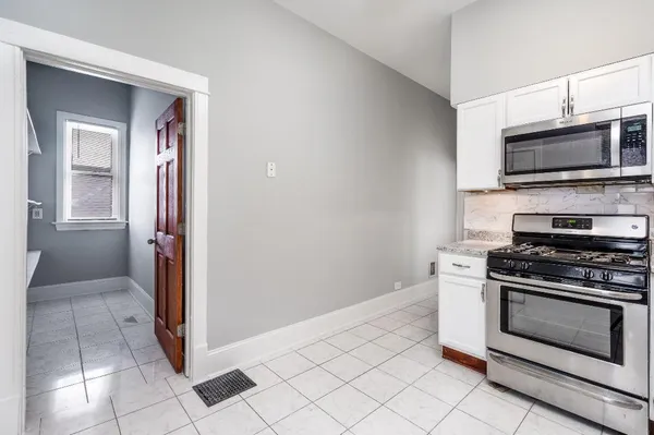 a kitchen with granite countertop a stove and a microwave