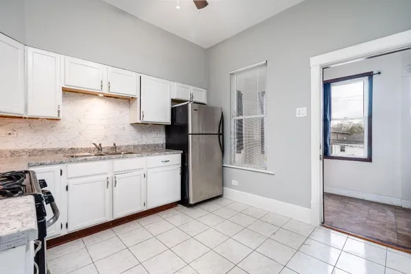 a kitchen with granite countertop cabinets and refrigerator