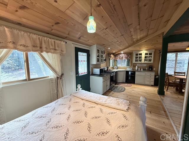 22258 Crestline Road Palomar Mountain, CA 92060 - Photo 27 of 56 a kitchen with stainless steel appliances kitchen island granite countertop a refrigerator stove oven dining table and chairs with wooden floor