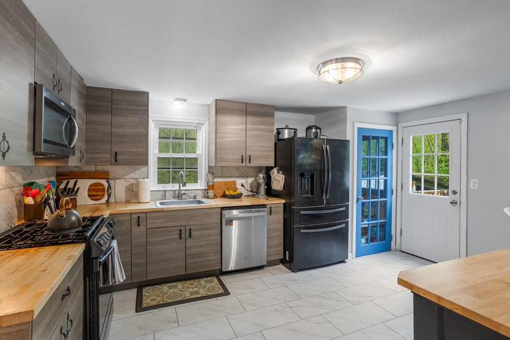 355 Wares Road Ashby, MA 01431 - Photo 14 of 38 a kitchen with stainless steel appliances granite countertop a stove top oven a refrigerator and a sink