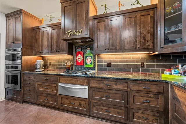 a kitchen with stainless steel appliances granite countertop a sink and cabinets