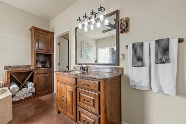 a spacious bathroom with a granite countertop sink a mirror and a shower