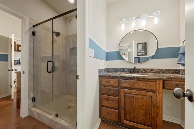 a bathroom with a granite countertop sink a shower and mirror