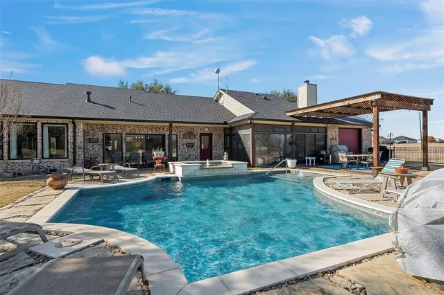 a view of a house with swimming pool and sitting area