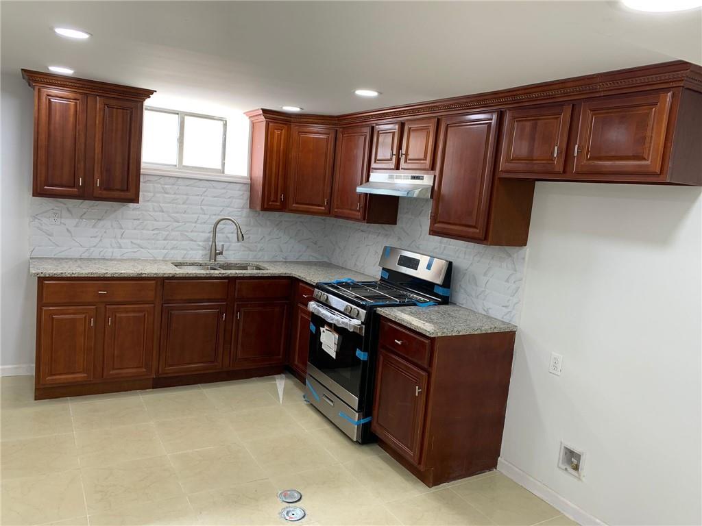 902 East 12th Street Brooklyn, NY 11230 - Photo 4 of 10 a kitchen with stainless steel appliances granite countertop a stove a sink dishwasher and a microwave