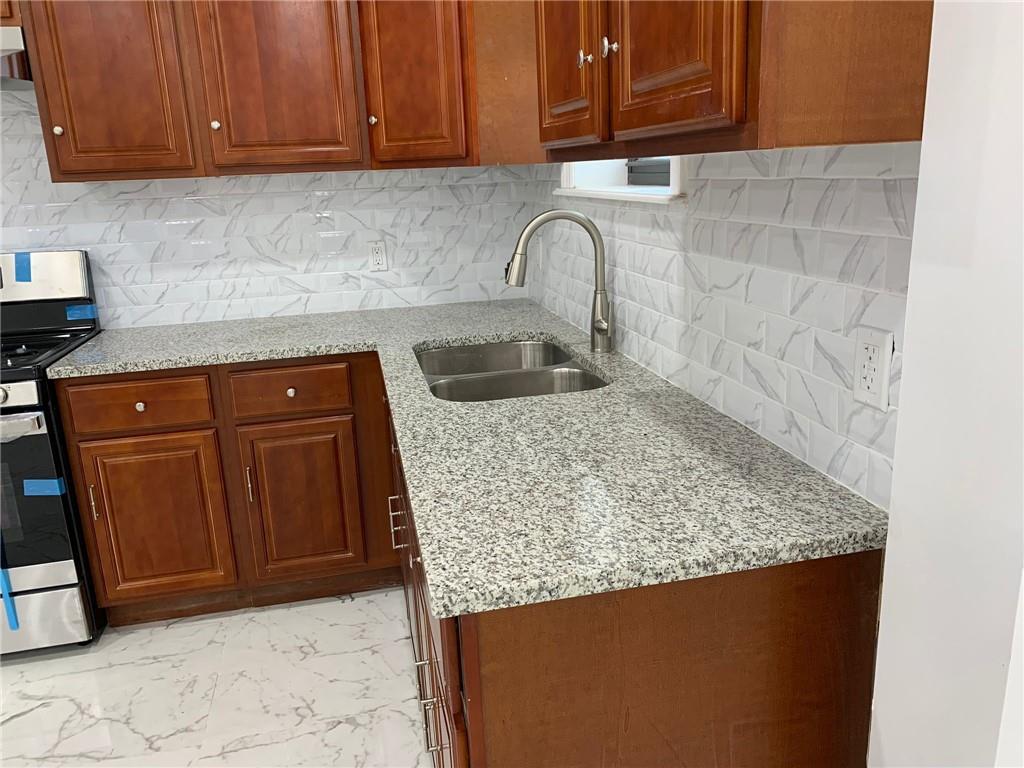 902 East 12th Street Brooklyn, NY 11230 - Photo 8 of 10 a kitchen with granite countertop a sink a stove and cabinets