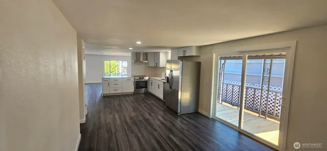 a kitchen with stainless steel appliances a refrigerator and wooden floor