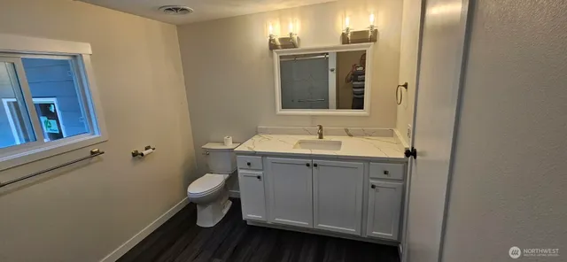 a bathroom with a toilet sink and mirror
