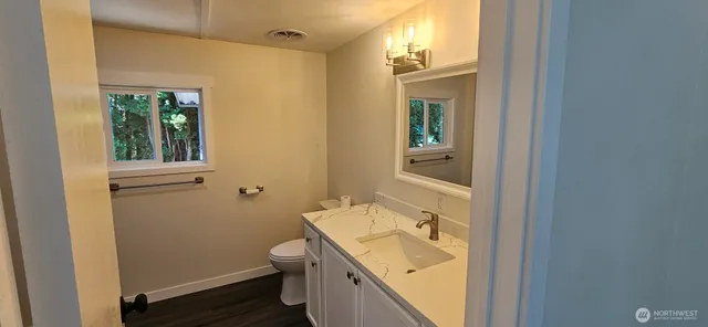 a bathroom with a sink and mirror with toilet