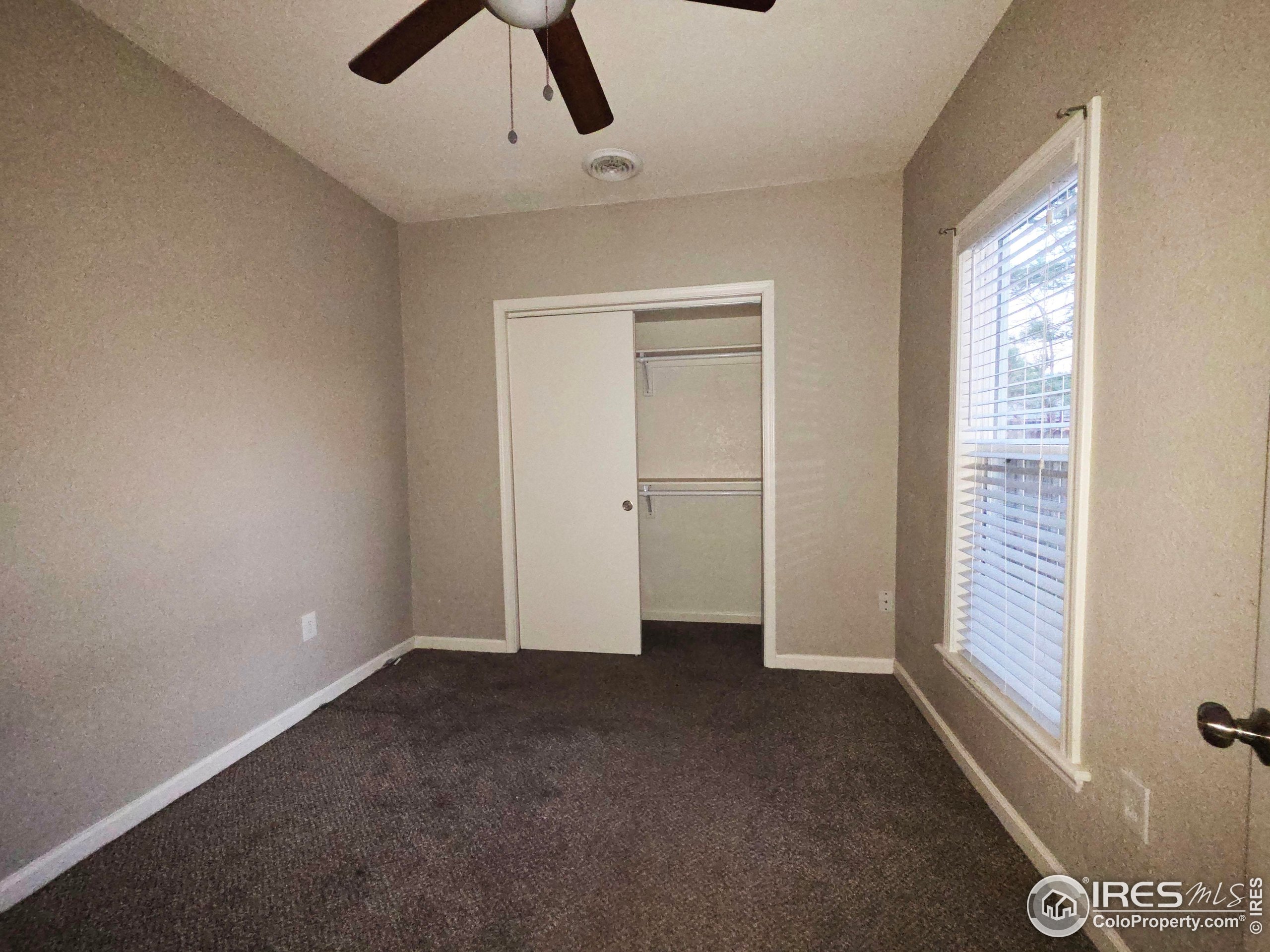 523 Chestnut Street Sterling, CO 80751 - Photo 6 of 13 an empty room with chandelier fan and windows