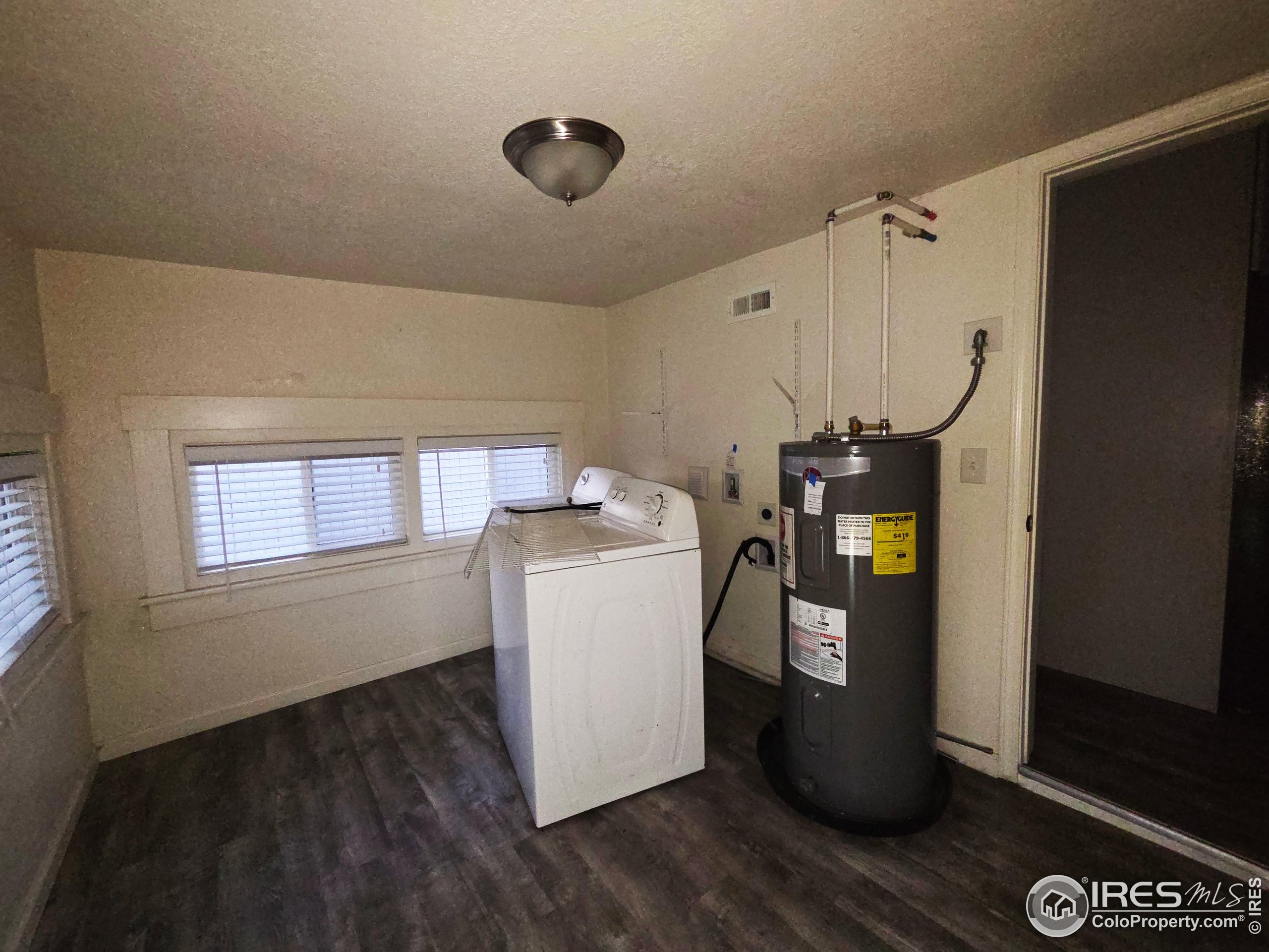 523 Chestnut Street Sterling, CO 80751 - Photo 9 of 13 a utility room with wooden floor washer and dryer