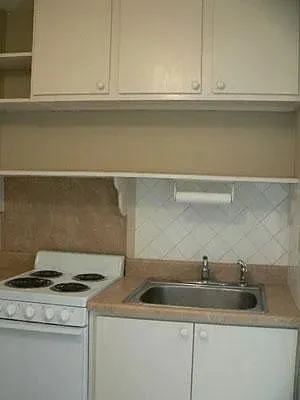 a kitchen with sink stove and cabinets