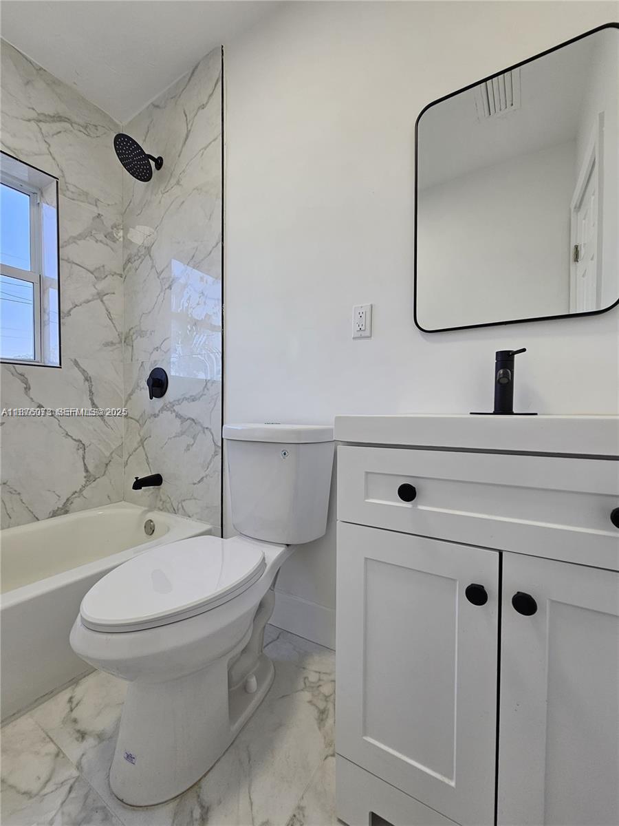 1117 West 26th Court Riviera Beach, FL 33404 - Photo 12 of 16 a white toilet sitting next to a bathroom sink