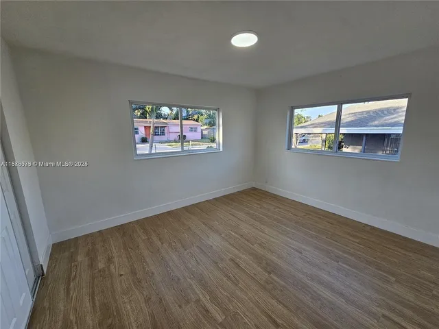 wooden floor in an empty room with a window