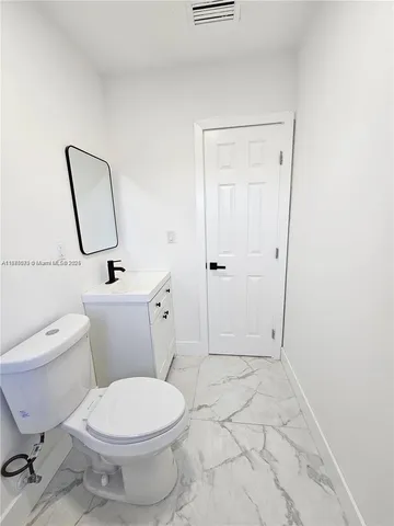 a white toilet sitting next to a bathroom sink