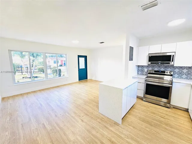 a kitchen with granite countertop a stove and a wooden floor
