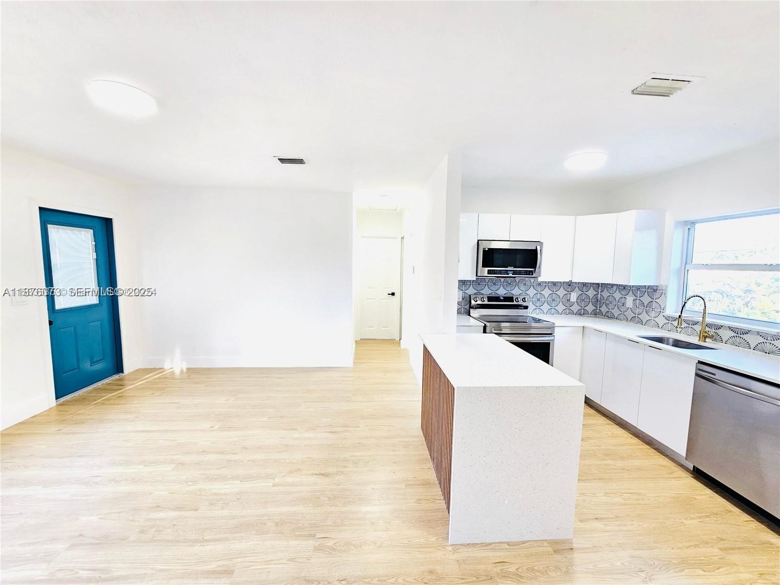 1117 West 26th Court Riviera Beach, FL 33404 - Photo 6 of 16 a large white kitchen with stainless steel appliances