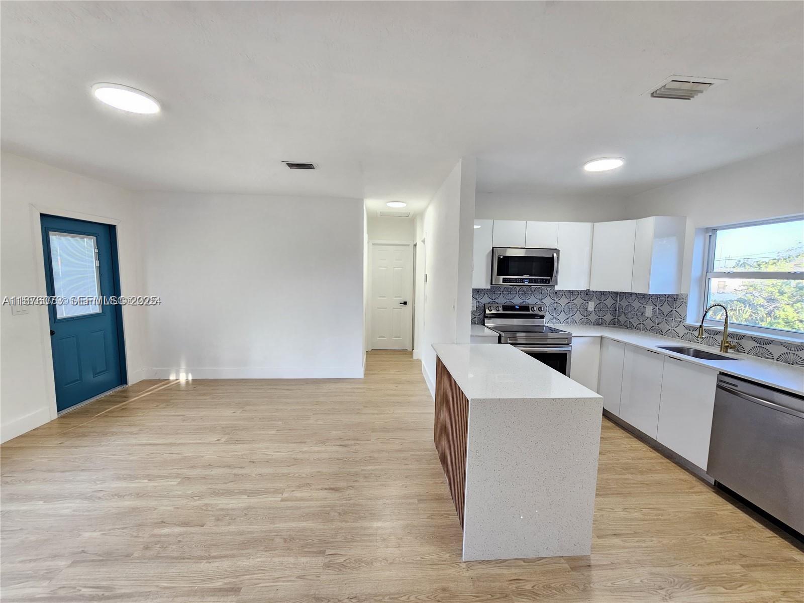 1117 West 26th Court Riviera Beach, FL 33404 - Photo 7 of 16 a large kitchen with cabinets and stainless steel appliances