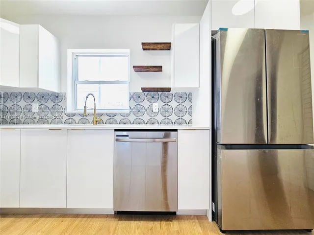 a kitchen with stainless steel appliances granite countertop a refrigerator and a sink