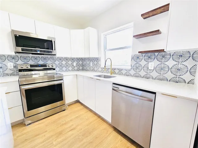 a kitchen with stainless steel appliances granite countertop a stove top oven microwave and cabinets