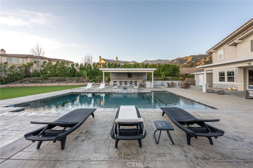 5062 Woodley Ridge Drive Rancho Cucamonga, CA 91739 - Photo 23 of 33 a swimming pool with outdoor seating and a garden