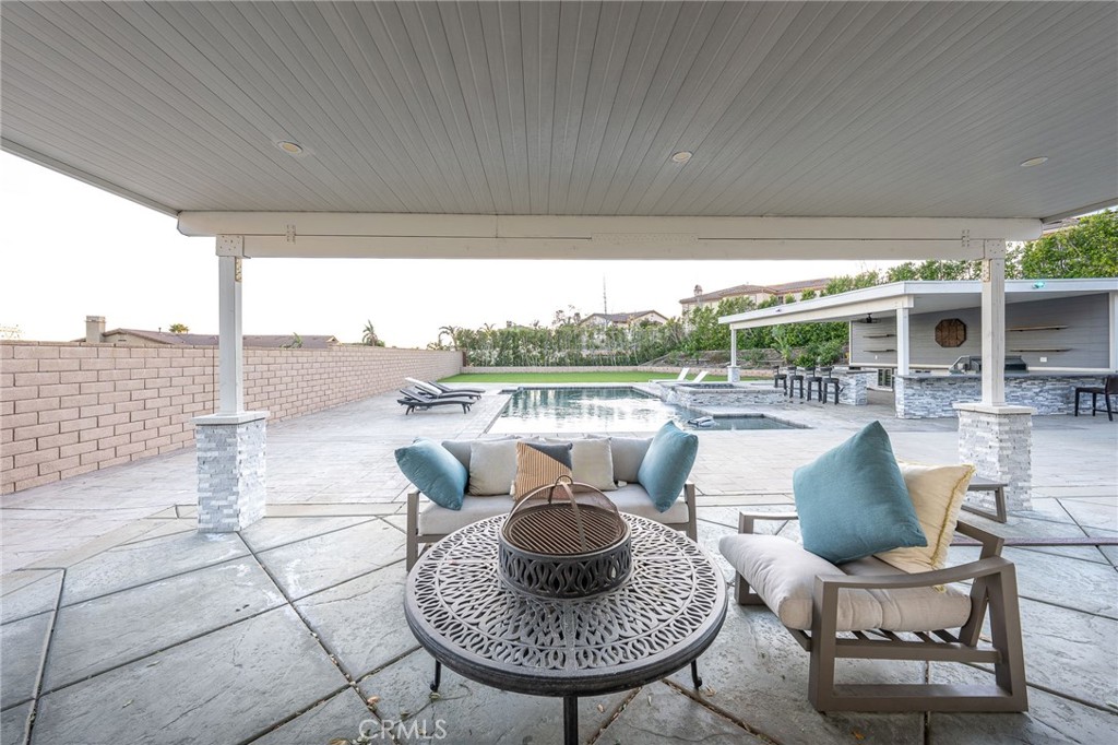 5062 Woodley Ridge Drive Rancho Cucamonga, CA 91739 - Photo 28 of 33 a view of a patio with couches chairs and a table and chairs
