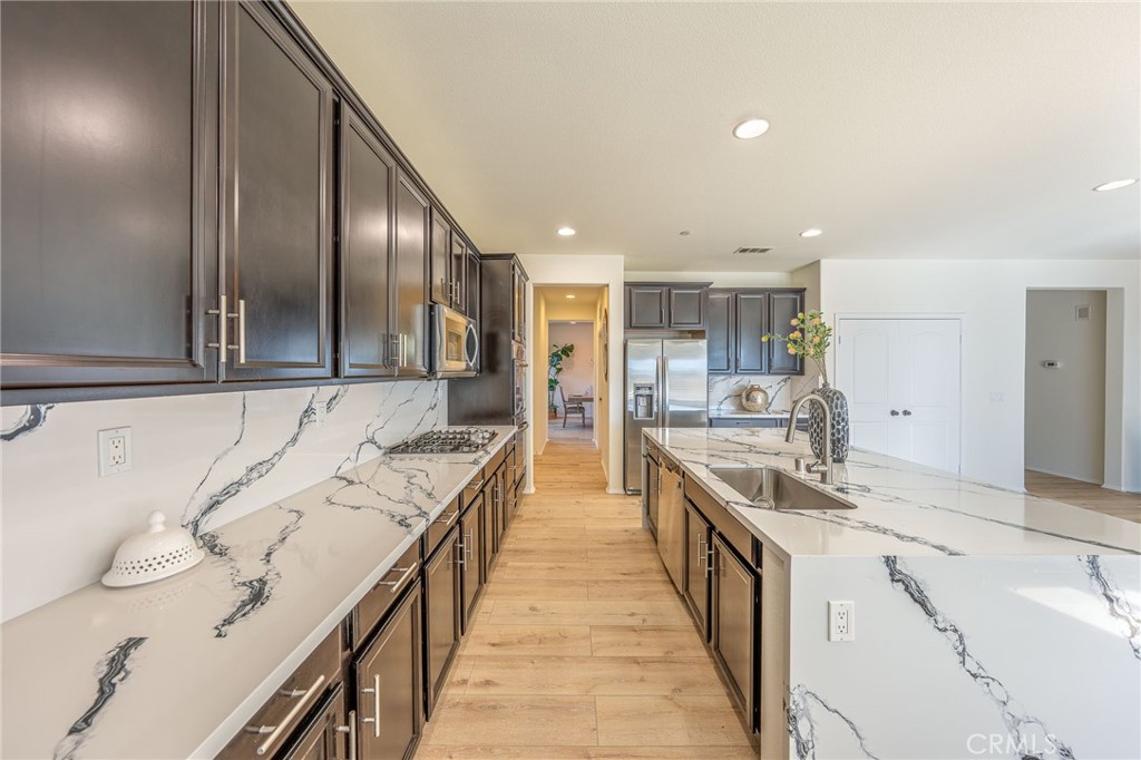 5062 Woodley Ridge Drive Rancho Cucamonga, CA 91739 - Photo 8 of 33 a large kitchen with a large counter top appliances and cabinets