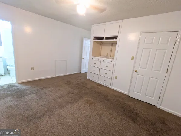 an empty room with a cabinet and mirrors