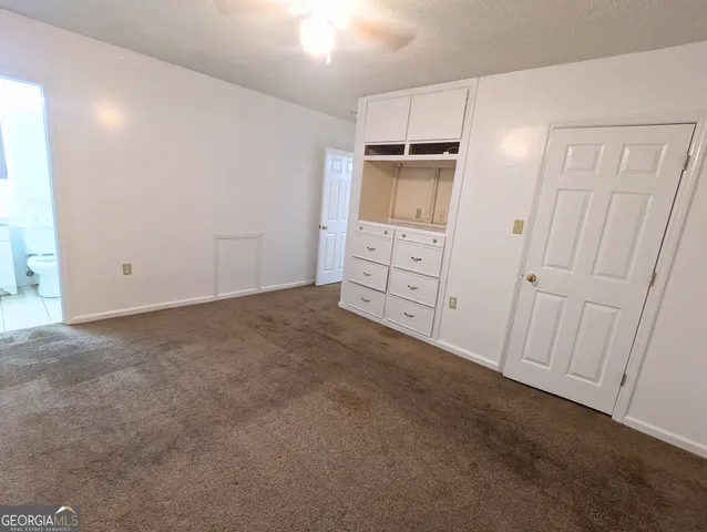 an empty room with a cabinet and mirrors
