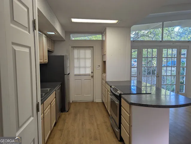 a kitchen with granite countertop a refrigerator and a sink