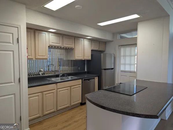 a kitchen with kitchen island granite countertop a sink stove and refrigerator